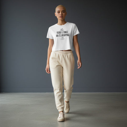 Model wearing Omina white cropped tee with Future is Female graphic, paired with beige sweatpants and sneakers.
