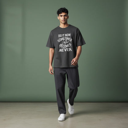 Model wearing a charcoal Omina graphic t-shirt with Do It Now text, made from premium combed cotton.