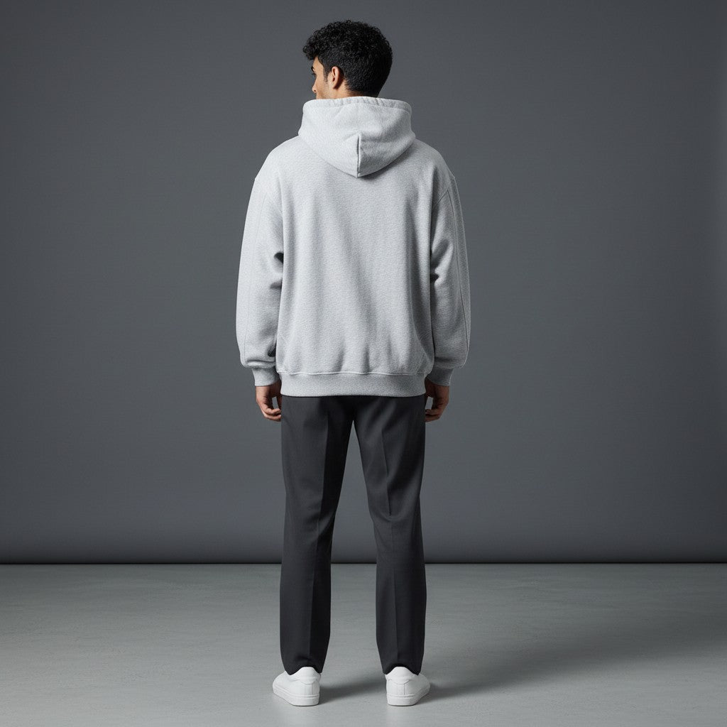 Back view of a man wearing an Omina grey boxy fleece zip hoodie with a drop shoulder fit and hood.