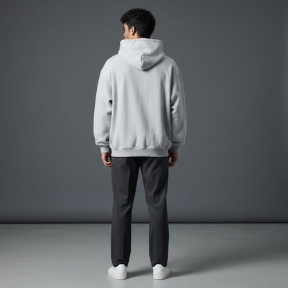 Back view of a man wearing an Omina grey boxy fleece zip hoodie with a drop shoulder fit and hood.