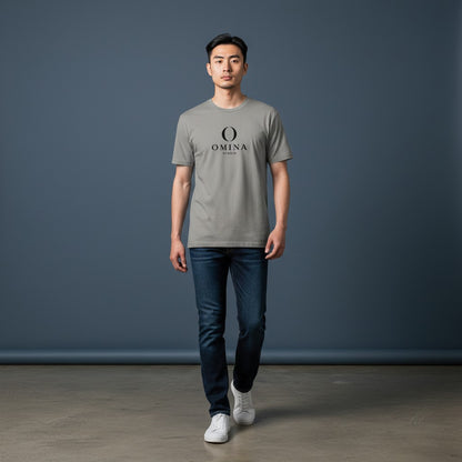 A man wearing an Omina grey cotton crew neck t-shirt with the Omina Studio mascot logo, paired with dark blue jeans.