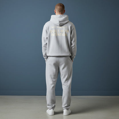 Omina grey fleeced boxy hoodie with "NOT PERFECT BUILT WITH INTENTION" graphic on back. Heavyweight cotton blend.