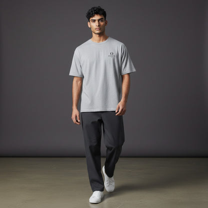 Model wearing a grey Omina heavyweight cotton t-shirt with a small Buddha logo on the chest, relaxed fit.