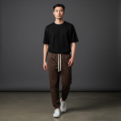 Omina Essentials heavyweight cotton sweatpants in dark brown with a cream drawstring and ribbed cuffs. Relaxed fit.