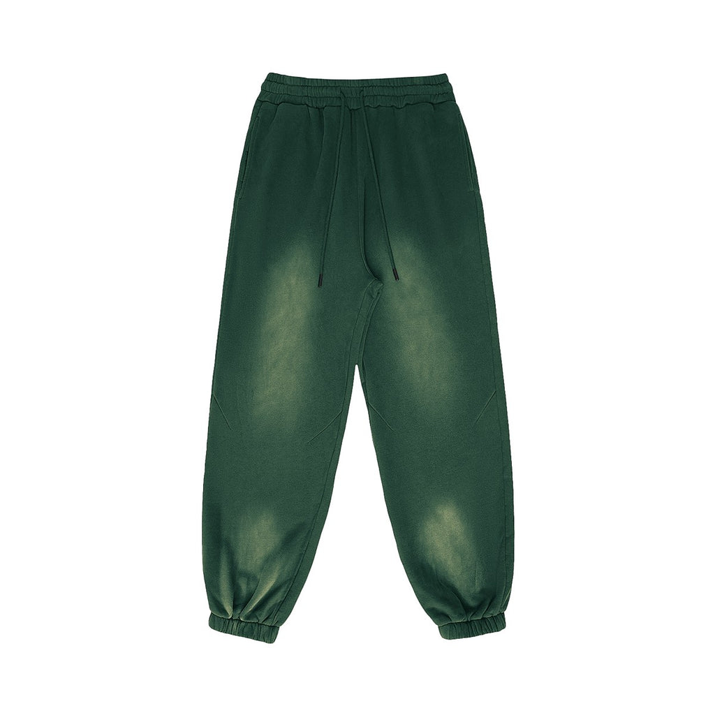 OMINA Studio vintage-inspired heavyweight fleece sweatpants in dark green with a washed finish and adjustable drawstrings.