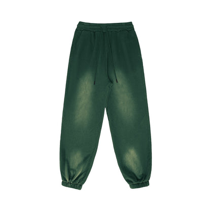OMINA Studio vintage-inspired heavyweight fleece sweatpants in dark green with a washed finish and adjustable drawstrings.