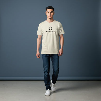 A man wearing an Omina Meet O T-shirt in cream cotton with a black logo graphic, paired with dark blue jeans.