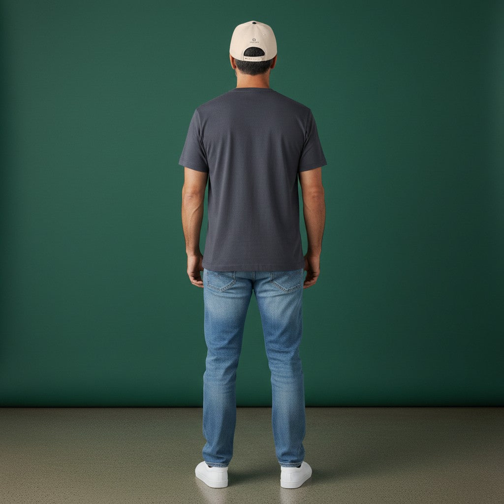 Man wearing an Omina beige 5-panel mid profile baseball cap with a snapback closure against a green background.