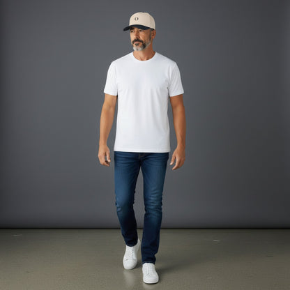 Model wearing an Omina mid profile baseball cap in beige with a black brim, white t-shirt, and blue jeans.
