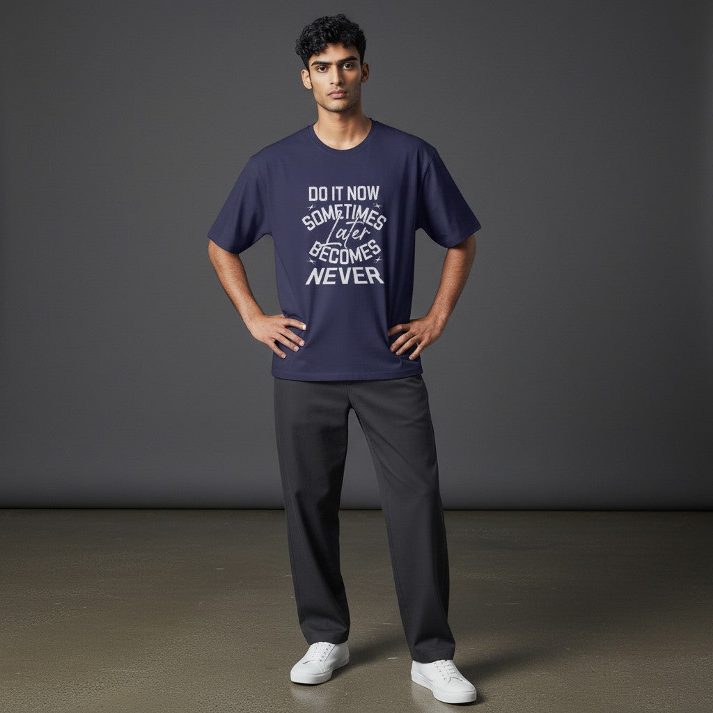 Model wearing a navy Omina classic fit cotton t-shirt with white Do It Now graphic text against a grey background.