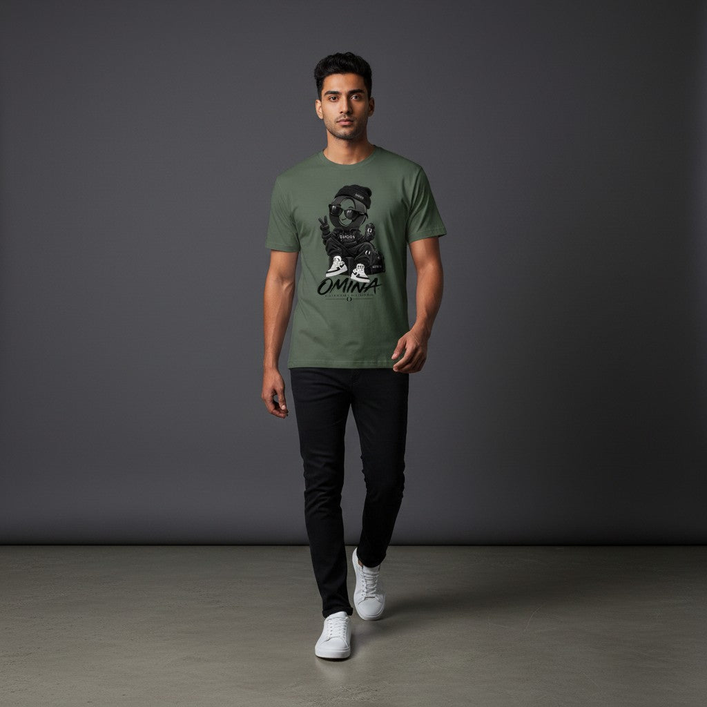 Model wearing an Omina olive green cotton t-shirt with a graphic print, paired with black jeans and white sneakers.