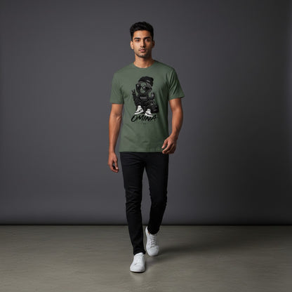 Model wearing an Omina olive green cotton t-shirt with a graphic print, paired with black jeans and white sneakers.