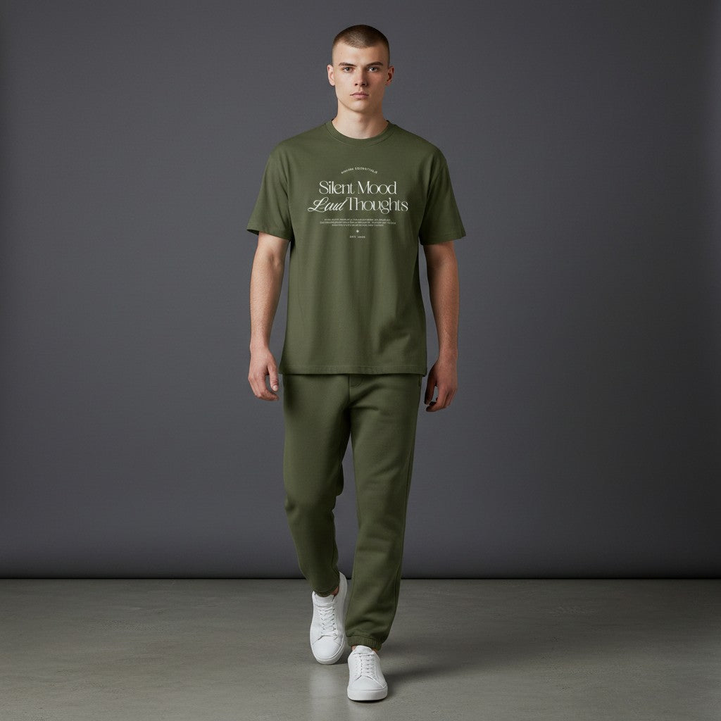 Omina Silent Mood olive green cotton jersey t-shirt worn by a male model with matching joggers and white sneakers.