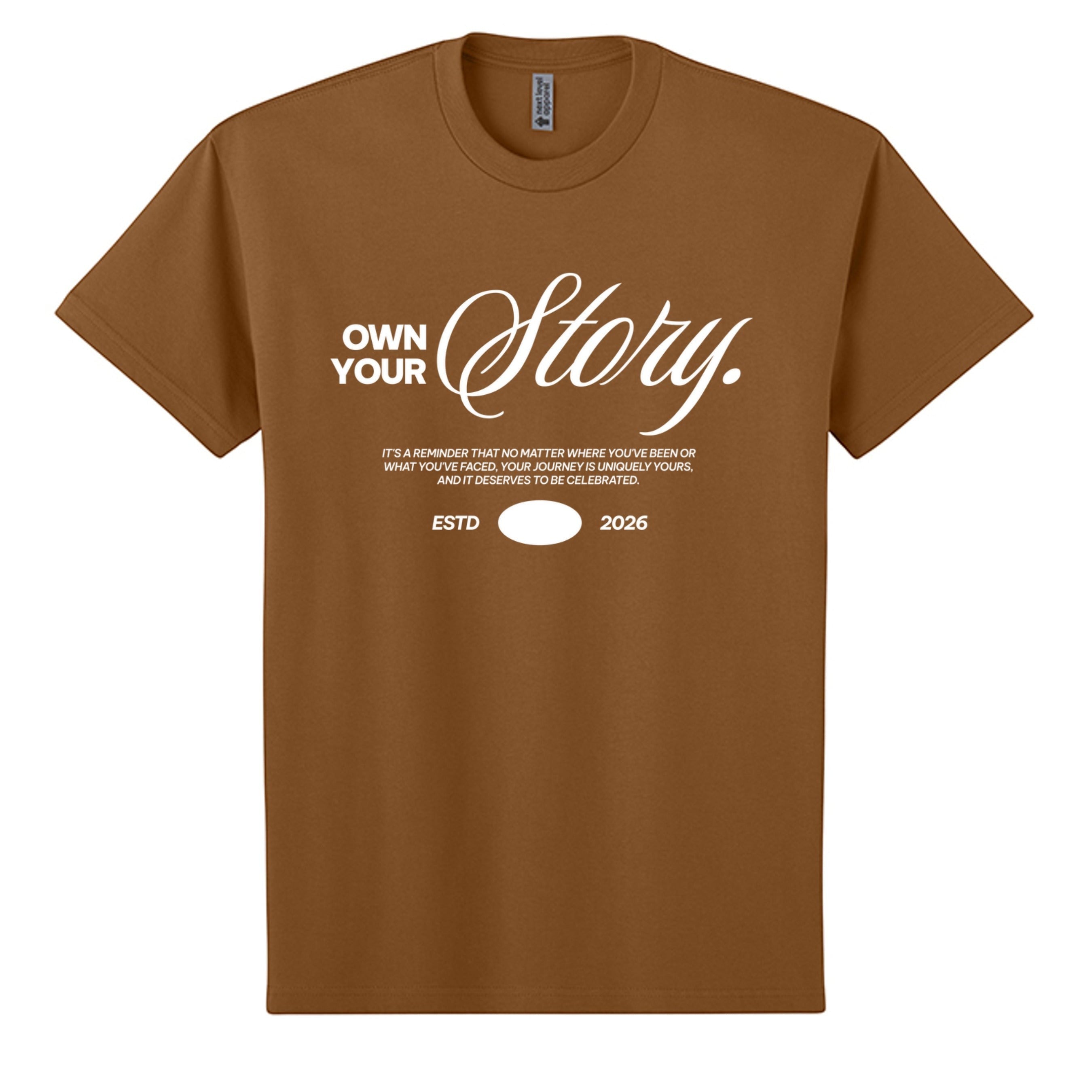 Omina brown heavyweight cotton oversized t-shirt with white "Own Your Story" graphic and "ESTD 2026" text.