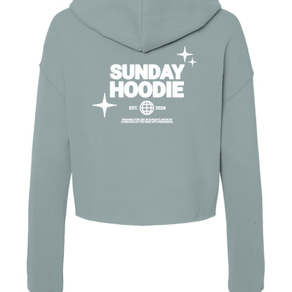 Back view of Omina Essentials sage green cropped Sunday hoodie with white graphic print and hood