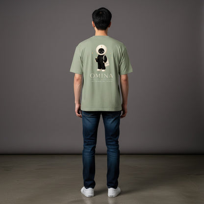 Model wearing an Omina sage green cotton crew neck t-shirt with a back graphic of the O mascot and brand text.