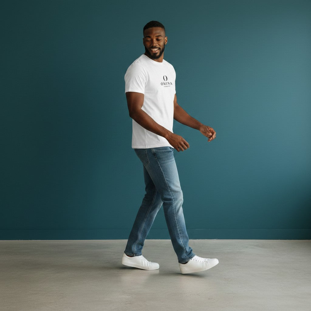 Man wearing a white Omina seamless cotton crew neck t-shirt with blue jeans against a dark teal background.