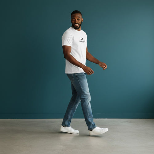 Man wearing a white Omina seamless cotton crew neck t-shirt with blue jeans against a dark teal background.