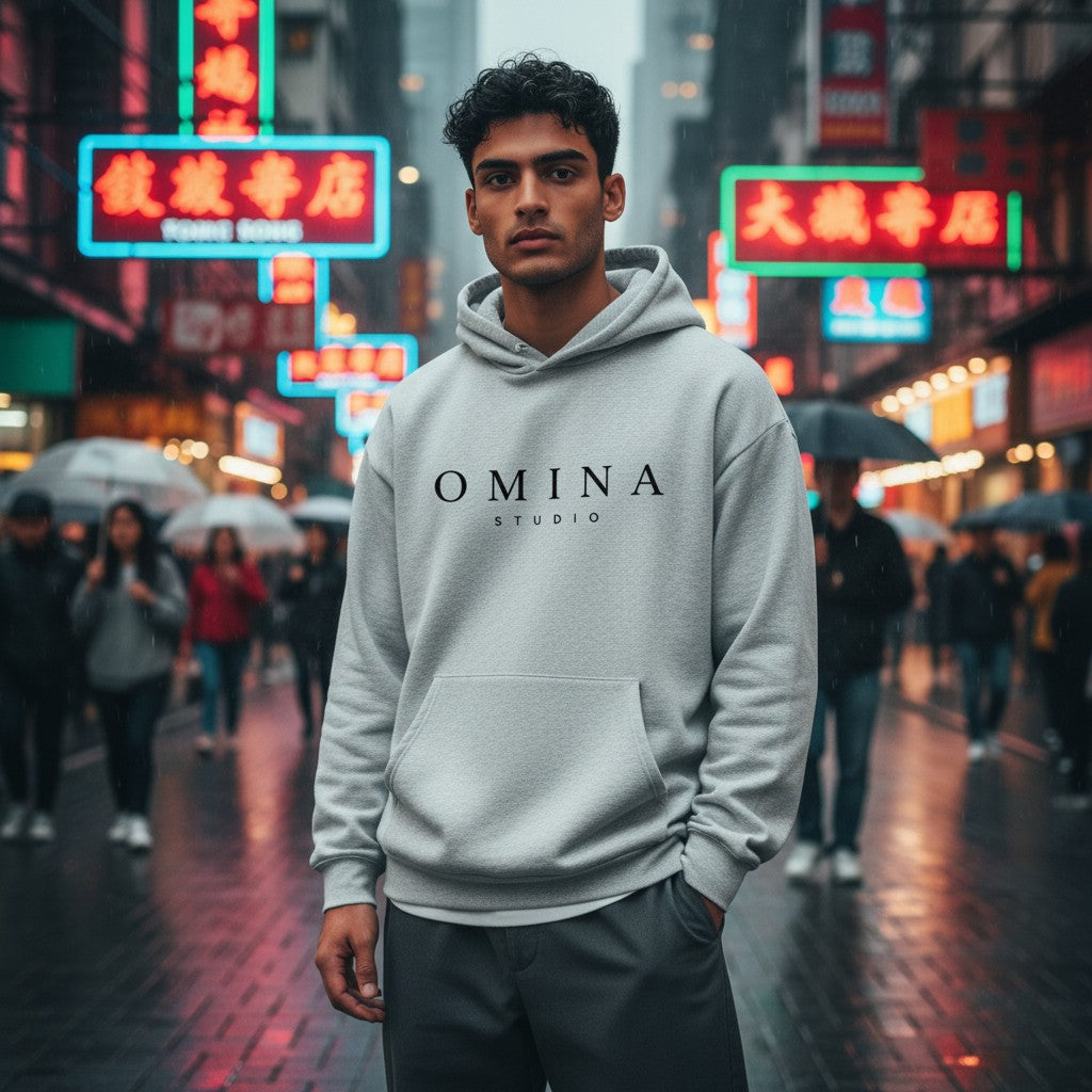 Omina Studio light grey heathered cotton-poly blend hooded sweatshirt with kangaroo pocket and black logo.