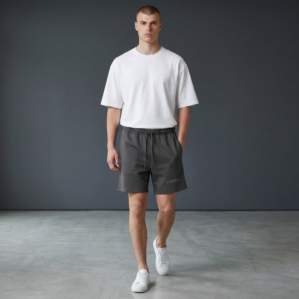 Omina Studio charcoal grey heavyweight French terry shorts with elastic waist, drawstring, and side pockets.