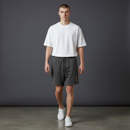 Omina Studio heavyweight charcoal French terry cotton shorts with drawstring and gold logo detail.