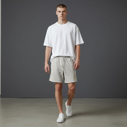Omina Studio light grey heavyweight cotton French terry shorts with drawstring and gold logo.