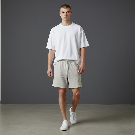 Omina Studio light grey heavyweight cotton French terry shorts with drawstring and gold logo.