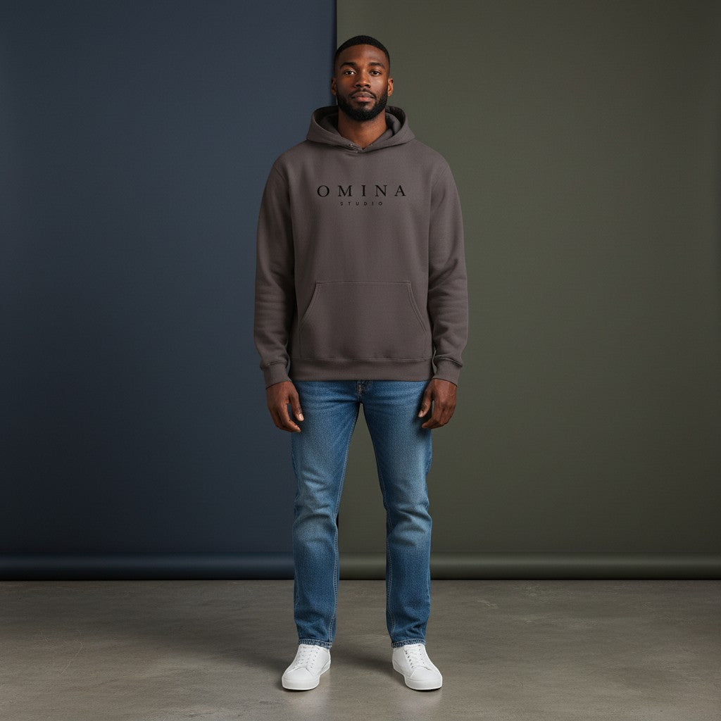 Omina Studio pigment-dyed charcoal grey cotton blend hoodie with front logo and relaxed fit.