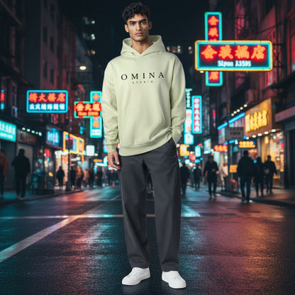 Omina Studio light green hooded sweatshirt with kangaroo pocket and black logo on chest.