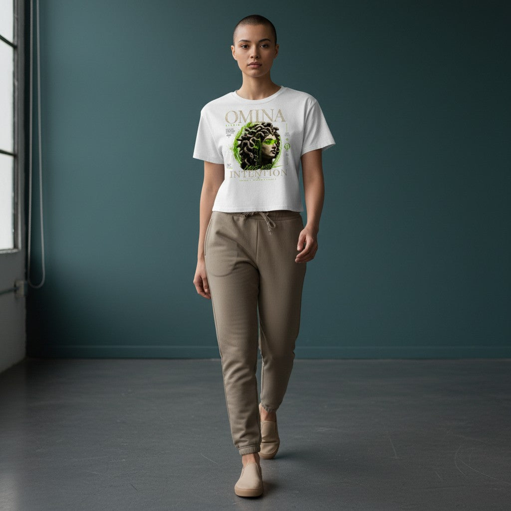 Omina Studio white cropped t-shirt with a Medusa bust graphic and green accents. Relaxed fit, raw hem.