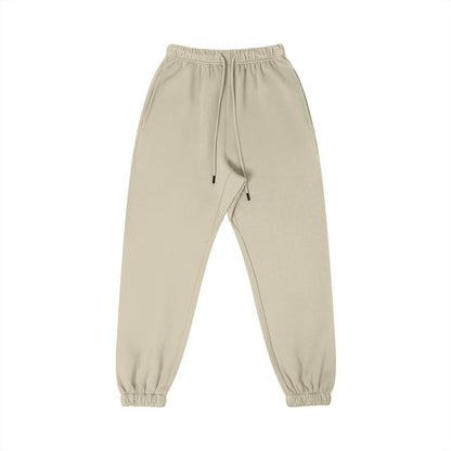 Omina Studio beige 100% combed cotton sweatpants with tapered fit, elastic waistband, drawstring, and cuffed ankles.