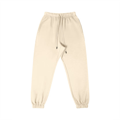 Omina Studio cream 100% combed cotton minimalist sweatpants with tapered fit, elastic waistband, drawstring, and cuffed ankles.
