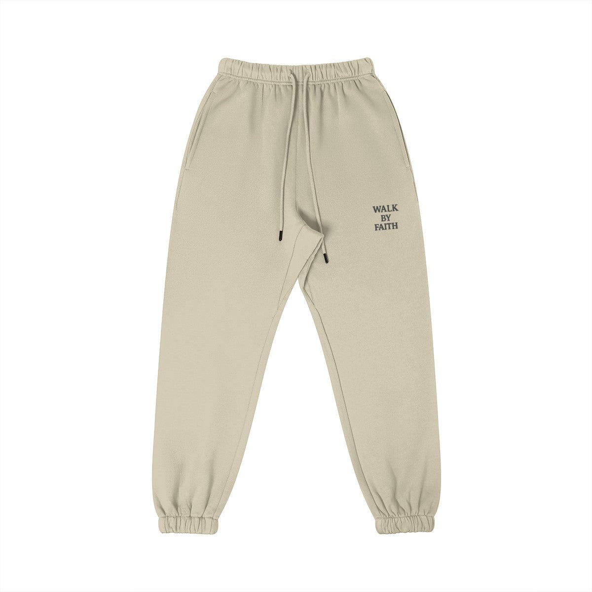 Omina Studio beige cotton sweatpants with "WALK BY FAITH" embroidered on the left thigh. Features an elastic waistband, drawstring, and tapered leg.