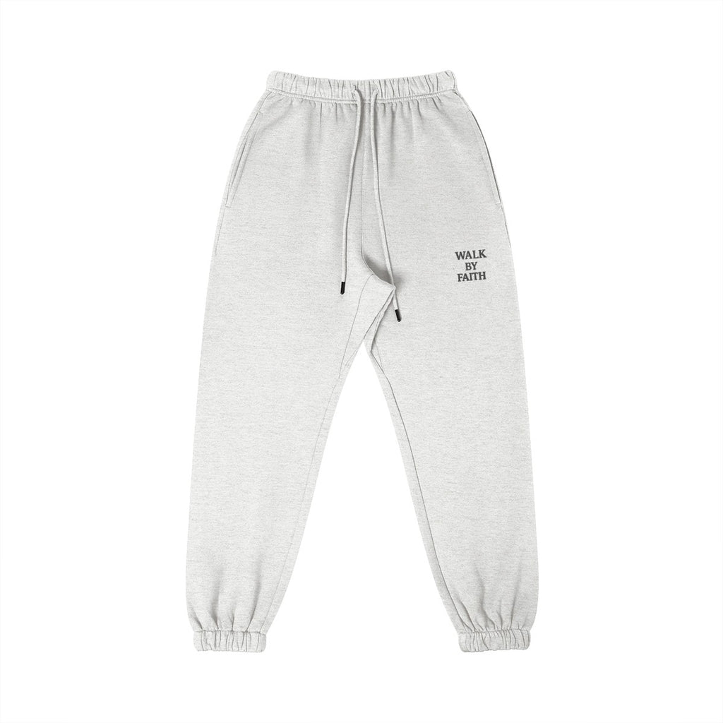 Omina Studio light grey cotton sweatpants with "Walk By Faith" text detail on the right thigh. Elastic waistband and cuffs.