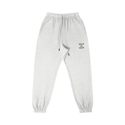 Omina Studio light grey cotton sweatpants with "Walk By Faith" text graphic on the right thigh.