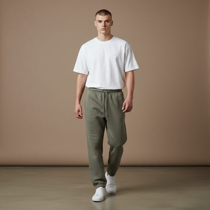 Omina Studio olive green heavyweight cotton sweatpants with "Walk By Faith" graphic and tapered fit.