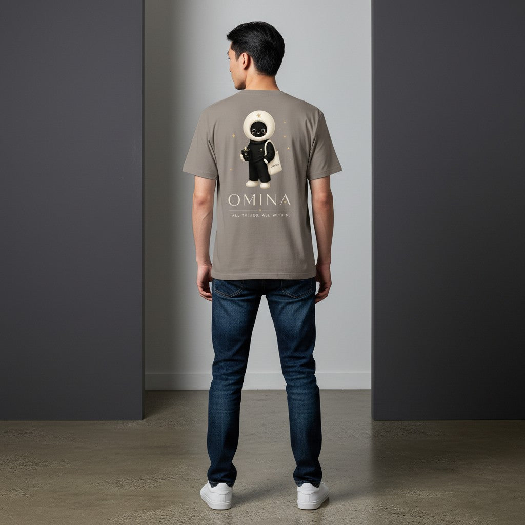 A man wearing an Omina taupe cotton t-shirt with a back graphic of the O mascot and Omina branding.