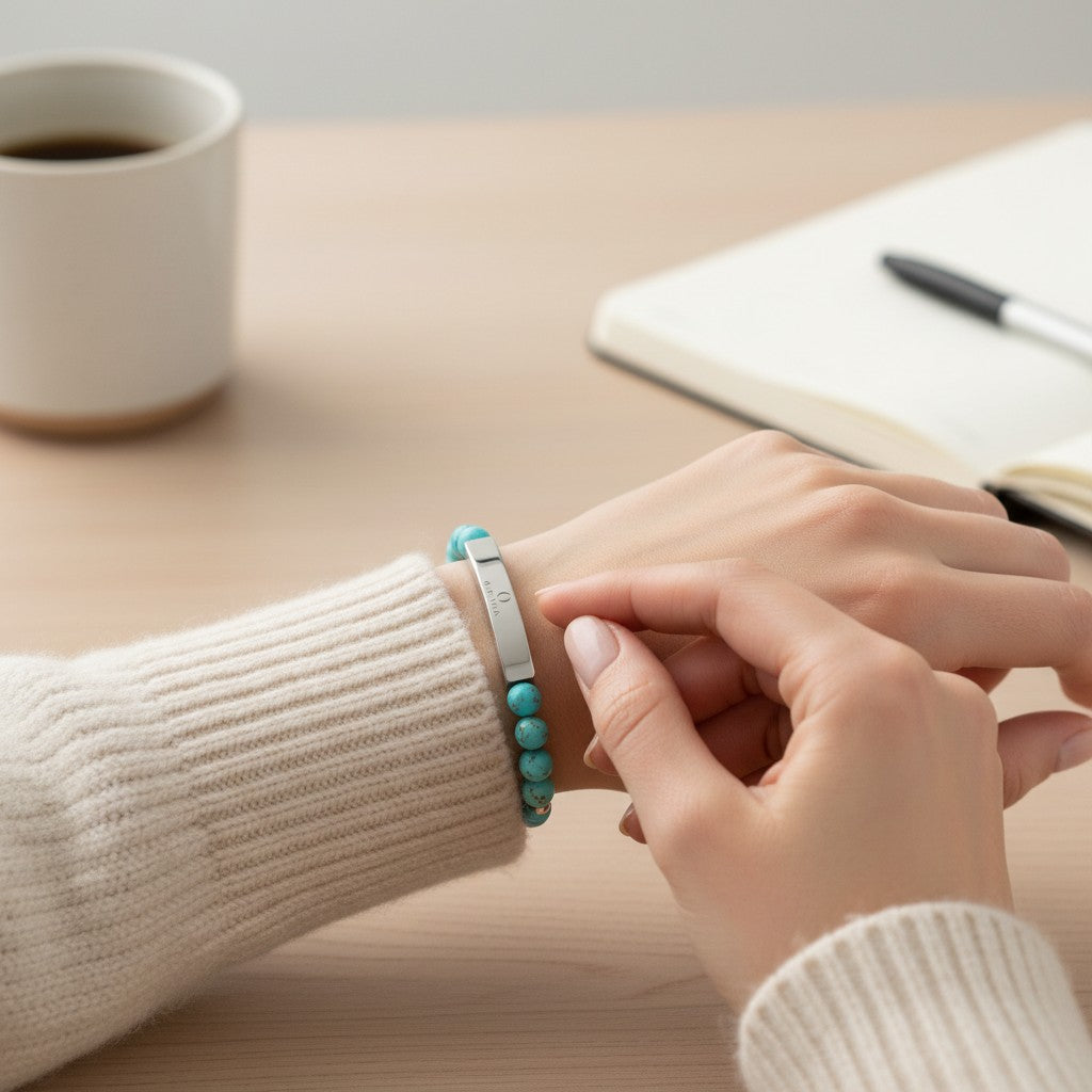 Omina turquoise natural stone stretch bracelet with a polished stainless steel engraved bar on a woman's wrist.