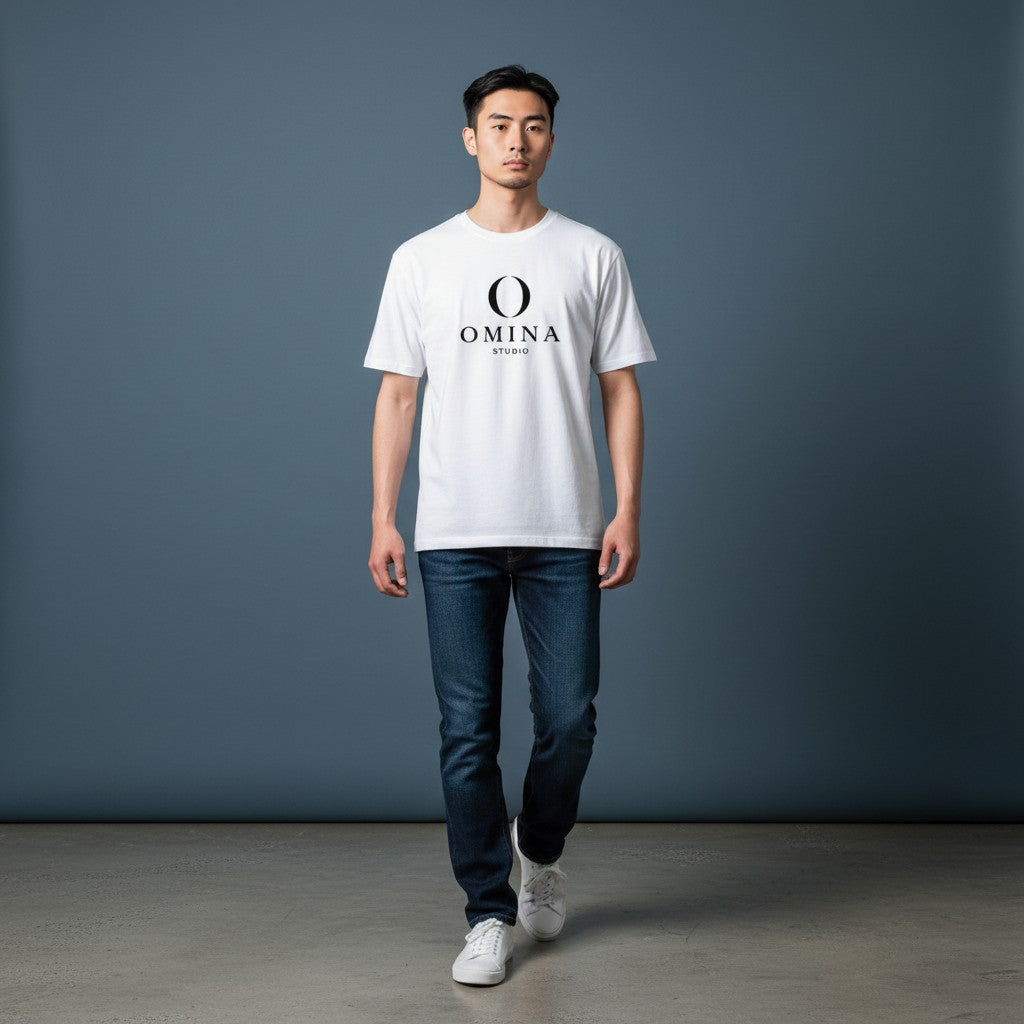 A man wearing an Omina white cotton crew neck t-shirt with a black Omina Studio logo graphic on the chest.
