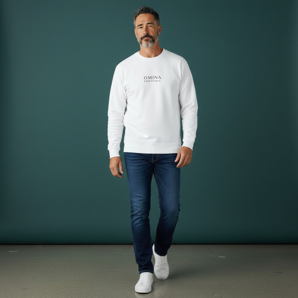 Model wearing a white Omina long sleeve cotton shirt with crew neck and logo, paired with blue jeans.
