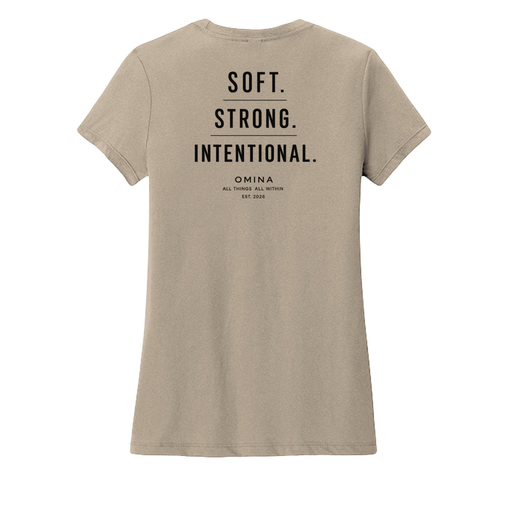 Omina women's tan crew neck t-shirt with black text reading SOFT. STRONG. INTENTIONAL. OMINA ALL THINGS ALL WITHIN EST. 2026