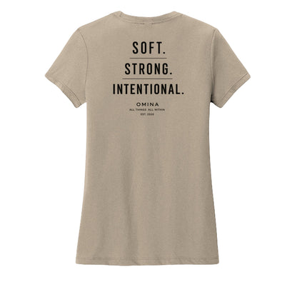 Omina women's tan crew neck t-shirt with black text reading SOFT. STRONG. INTENTIONAL. OMINA ALL THINGS ALL WITHIN EST. 2026