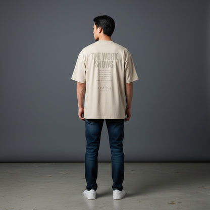 Omina beige cotton t-shirt with "The Work Shows" graphic print on back, relaxed fit, worn by a man.