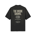 Omina black cotton t-shirt with "THE WORK SHOWS." graphic print on back.