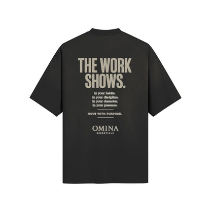 Omina black cotton t-shirt with "THE WORK SHOWS." graphic text and minimalist logo.