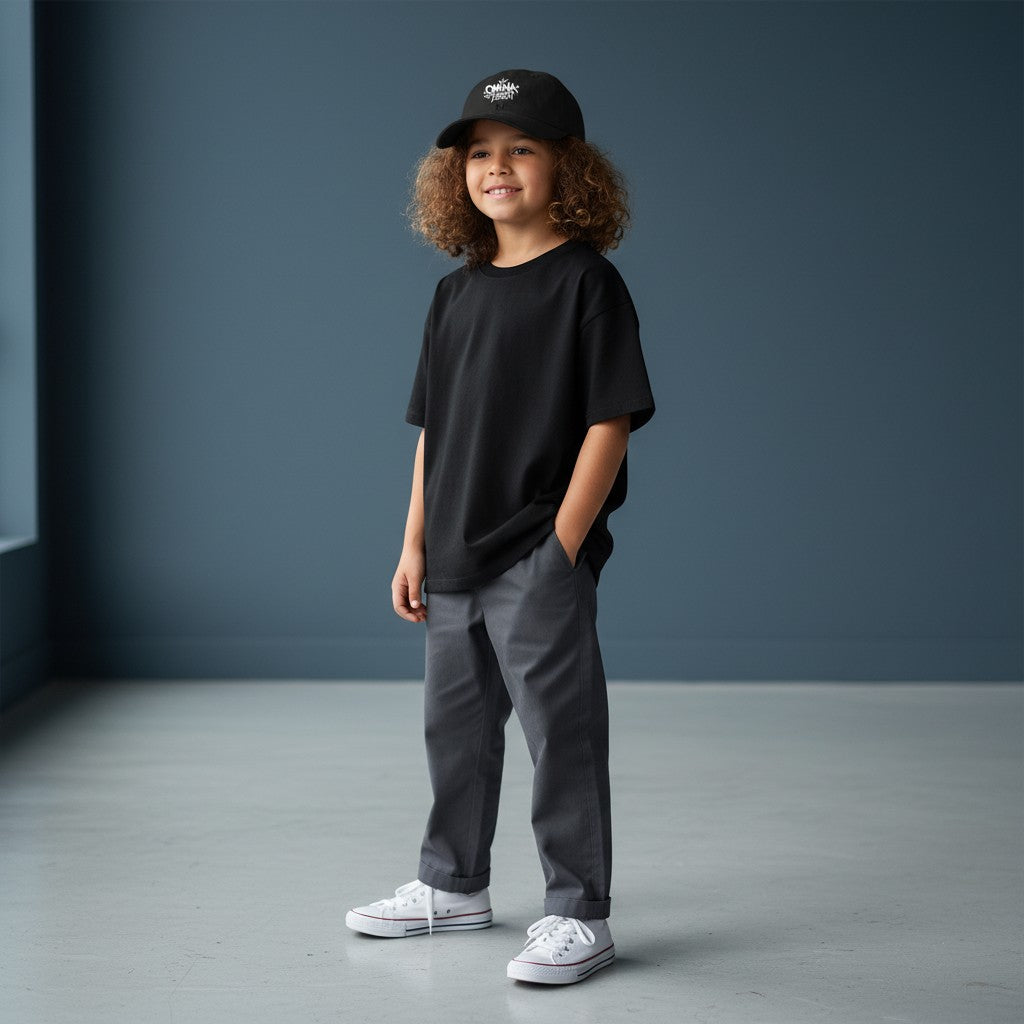 Omina Youth black cotton twill low-profile cap with white graffiti-style logo and adjustable buckle closure.