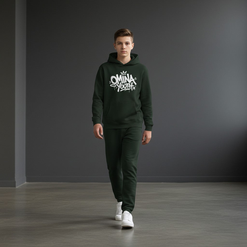 A boy wearing an Omina dark green fleece hoodie with white graffiti-style chest graphic and matching joggers.