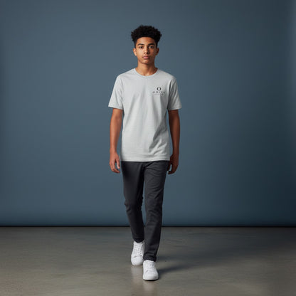 A young man wearing an Omina grey performance tee with a small logo on the chest, paired with dark trousers.