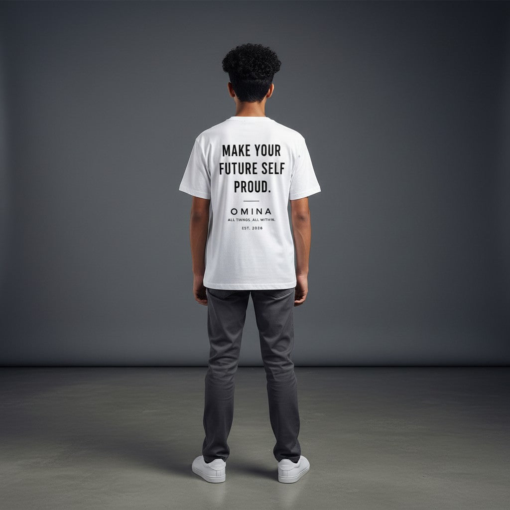 A youth wearing a white Omina performance tee with Future Self Proud text on the back, viewed from behind.