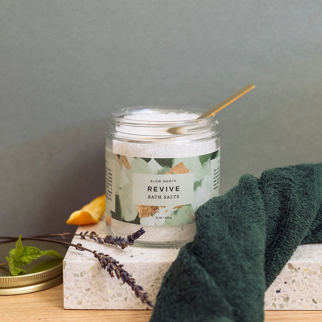 Slow North Revive Bath Salts in a 15 oz jar, showing the natural, textured bath salts for relaxing body care.
